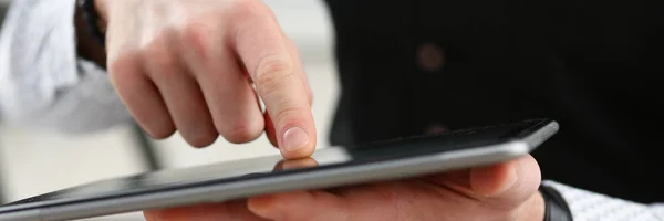 Dedo do braço masculino usando tablet pc display — Fotografia de Stock