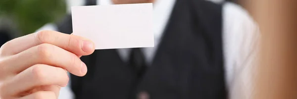 Male hand in suit give blank calling card to visitor