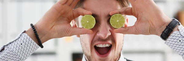 Mãos masculinas segurar uma fruta de corte no nível dos olhos — Fotografia de Stock