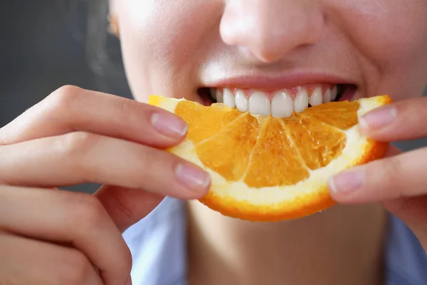 Linda morena sorrindo mulher comer laranja fatiada — Fotografia de Stock