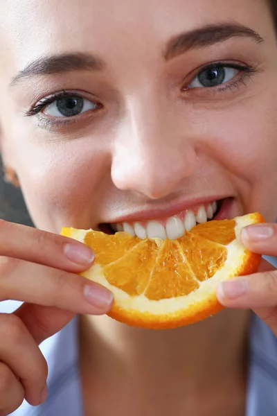 Linda morena sorrindo mulher comer laranja fatiada — Fotografia de Stock