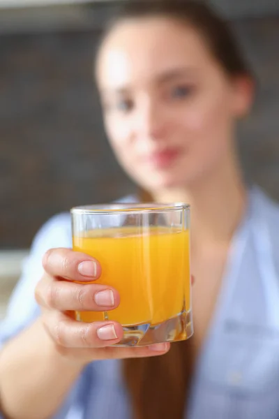 Mulher bonita segurar nos braços de vidro de suco de laranja — Fotografia de Stock