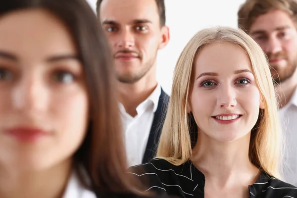 Group of smiling people stand in office looking