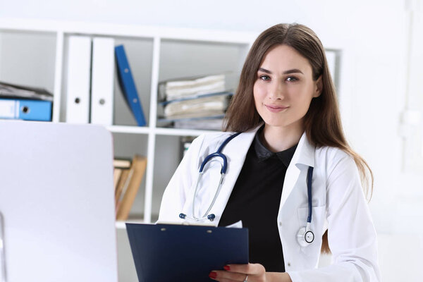 Beautiful smiling female doctor hold clipboard