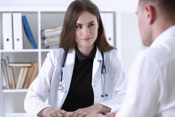 Bonita sorridente fêmea médico segurar caneta de prata — Fotografia de Stock