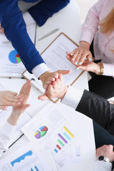 Group of people in suits crossed hands