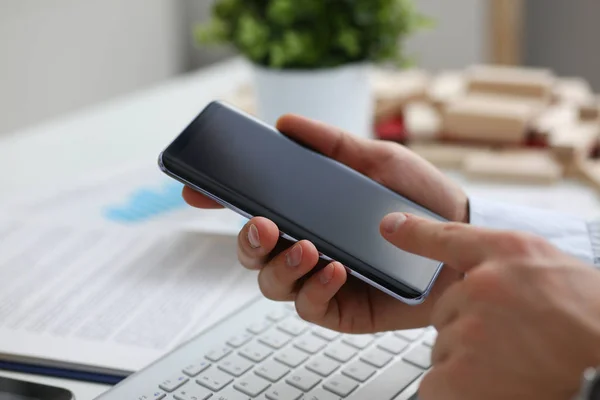 A businessman holds a new smartphone in