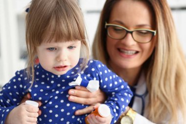 Küçük çocuk ile anne çocuk doktoru resepsiyonda