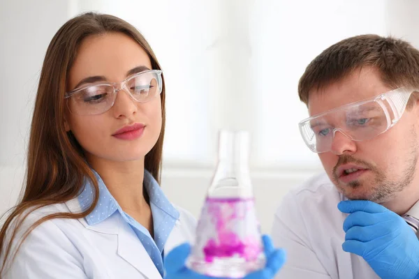 Técnico segurar nos braços em luvas de proteção frasco de amostra — Fotografia de Stock