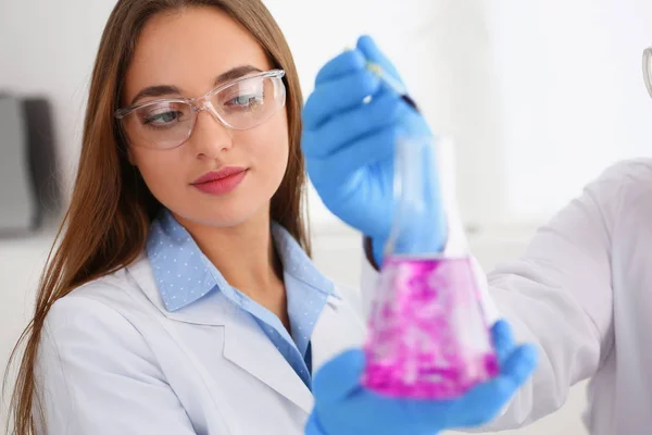 Technician hold in arms in protective gloves sample bottle — Stock Photo, Image