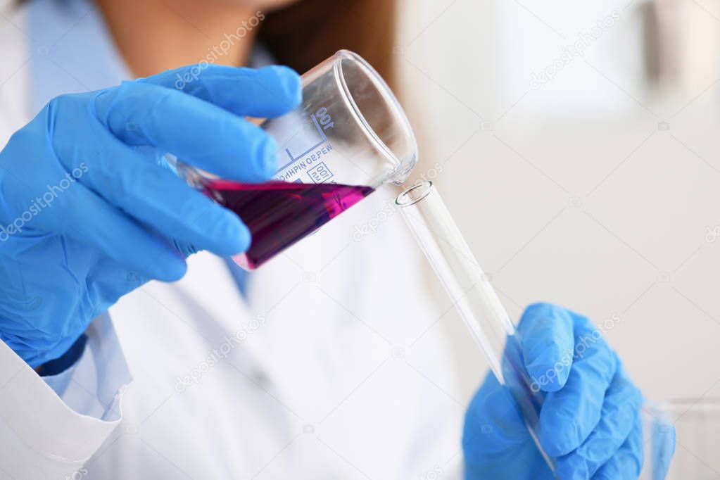 Female chemist holds test tube of glass in his hand