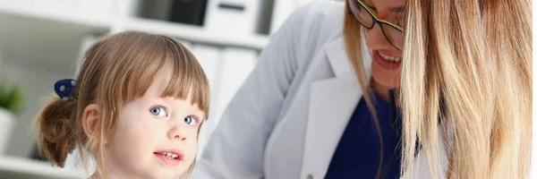 Маленький ребенок со стетоскопом на приеме у врача — стоковое фото