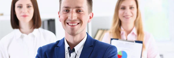 Group of smiling people stand in office looking