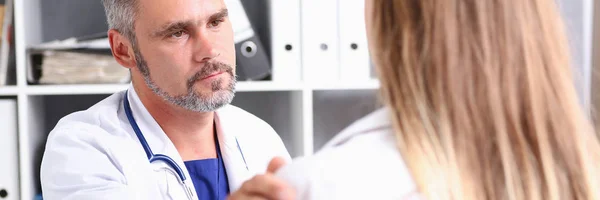 Friendly male doctor hold patient shoulder