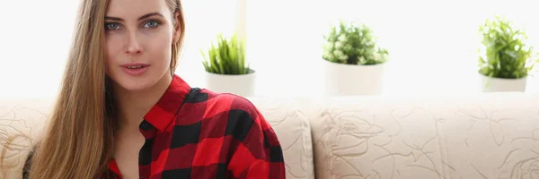 Young blond woman sit on sofa in room — Stock Photo, Image