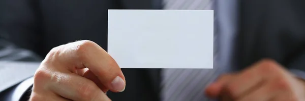 Brazo masculino en traje dar tarjeta de visita en blanco — Foto de Stock