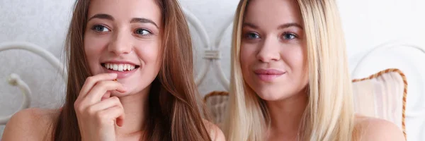 Dos amigas sonrientes felices comen palomitas de maíz en la cama —  Fotos de Stock