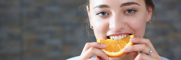 Linda morena sorrindo mulher comer laranja fatiada — Fotografia de Stock