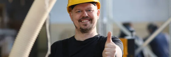 Trabalhador sorrindo em amarelo capacete mostrar confirmar sinal — Fotografia de Stock