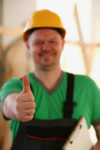 Lächelnder Arbeiter mit gelbem Helm zeigt Schild — Stockfoto