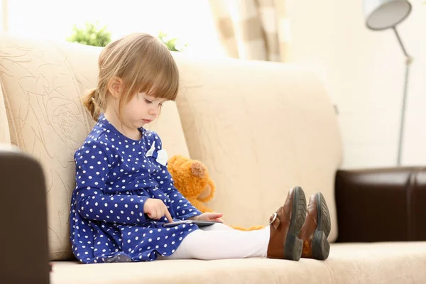 Carino bambina sul divano utilizzare il cellulare — Foto Stock