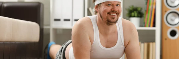 Jovem homem de fitness atraente encontra-se em um tapete de gordura com — Fotografia de Stock