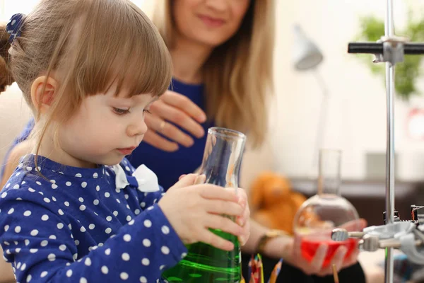 Woman and little girl play with colourful liquids — Stock Photo, Image