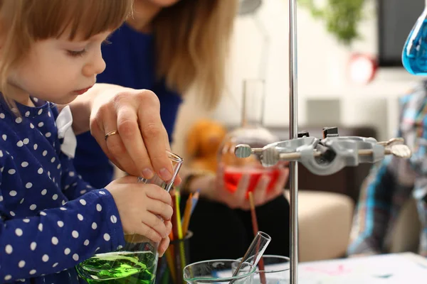 Woman and little girl play with colourful liquids — Stock Photo, Image