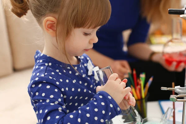 Woman and little girl play with colourful liquids — Stock Photo, Image