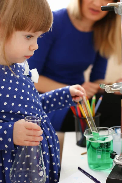 Woman and little girl play with colourful liquids — Stock Photo, Image