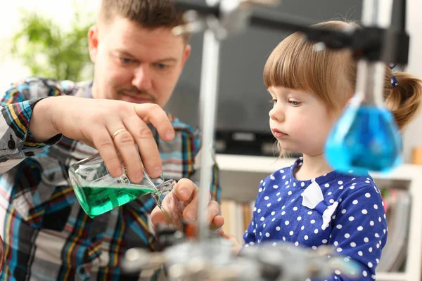 Man and little girl play with colourful liquids — Stock Photo, Image