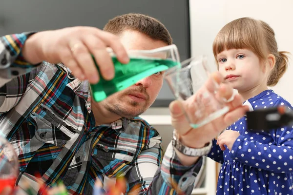 Man and little girl play with colourful liquids — Stock Photo, Image