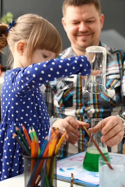 Man and little girl play with colourful liquids — Stock Photo, Image