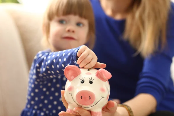 Niño niña brazo poner monedas en piggybank —  Fotos de Stock