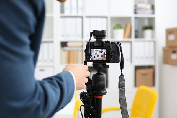 Male arms in suit mount camcorder to tripod — Stock Photo, Image
