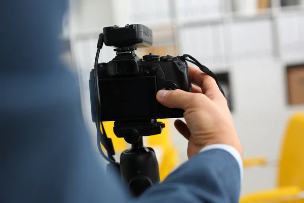 Male arms in suit mount camcorder to tripod — Stock Photo, Image