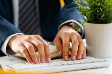 Gümüş klavyede yazarak takım elbiseli erkek silah