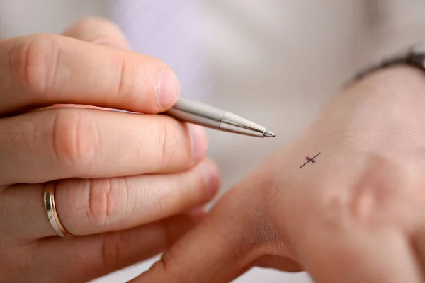 Masculino fazer x cruz nota com prata caneta no seu braço — Fotografia de Stock