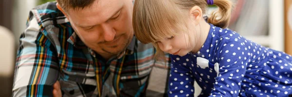 Söt liten flicka på golvet matta med pappa — Stockfoto