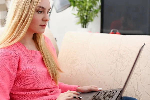 Young beautiful blond woman sit on the sofa in livingroom hold laptop in arms — Stock Photo, Image