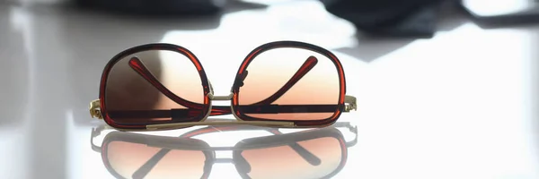 Óculos de sol jazem sobre a mesa com closeup reflexão — Fotografia de Stock