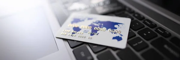 Blanco de plástico de la tarjeta de crédito mentira en el portátil negro — Foto de Stock