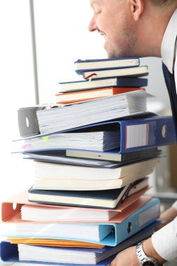 Ofis çalışanı büyük miktarda belgeyi kaldırmaya çalışıyor.