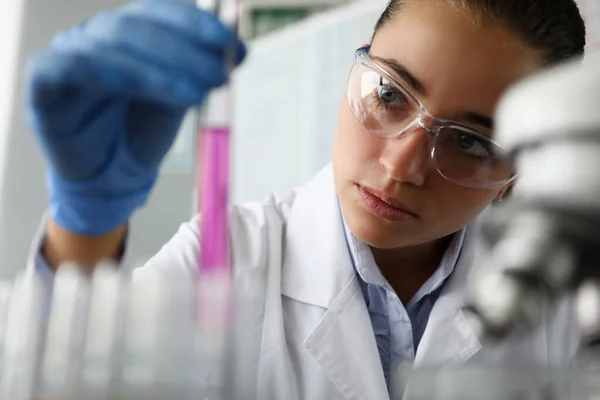 Женщина-ученый в лаборатории держит пробирку с — стоковое фото