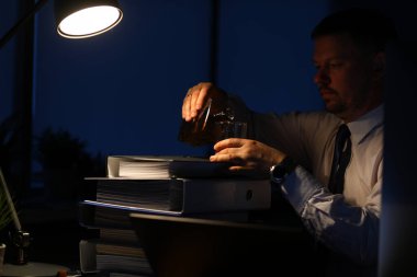 Yorgun erkek alkollü içecekler içiyor.