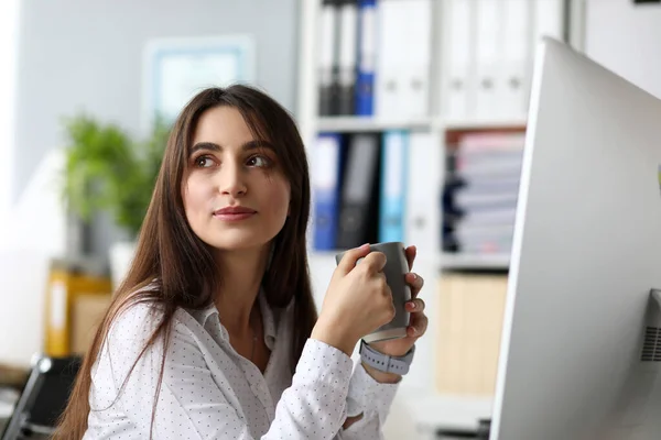 Mujer alegre positiva sentada en la mesa de trabajo agua potable — Foto de Stock