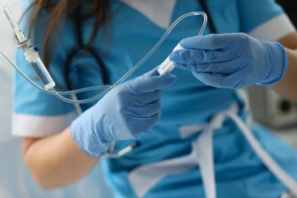 Enfermeira feminina mão em luvas de proteção azul segurar conta-gotas — Fotografia de Stock