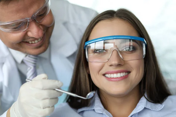 与快乐微笑的女访客一起工作的男牙医 — 图库照片