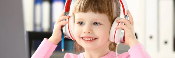 Niña usando auriculares use computadora móvil —  Fotos de Stock