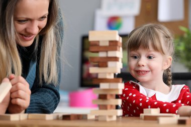 Küçük kızı olan genç anne tahta blokta oyun oynuyor.
